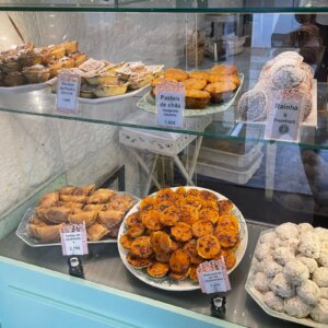 Selection of traditional Portuguese pastries displayed inside a local pastry shop.