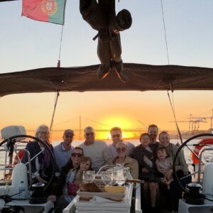 Private group enjoying a sunset sailing experience on the Tagus River in Lisbon with views of the 25 de Abril Bridge