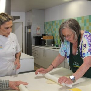 Clients learning traditional Portuguese pastry techniques at a cooking workshop in Lisbon.
