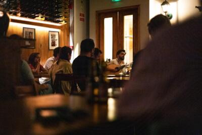 A Portuguese guitarist performing in a traditional fado house in Lisbon during an intimate experience with an attentive audience.