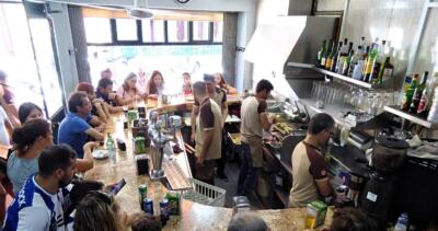 Guests at a traditional tavern in Porto during the Private Porto Food Tour, tasting regional snacks, bifanas, and Portuguese beer in an authentic and welcoming atmosphere.