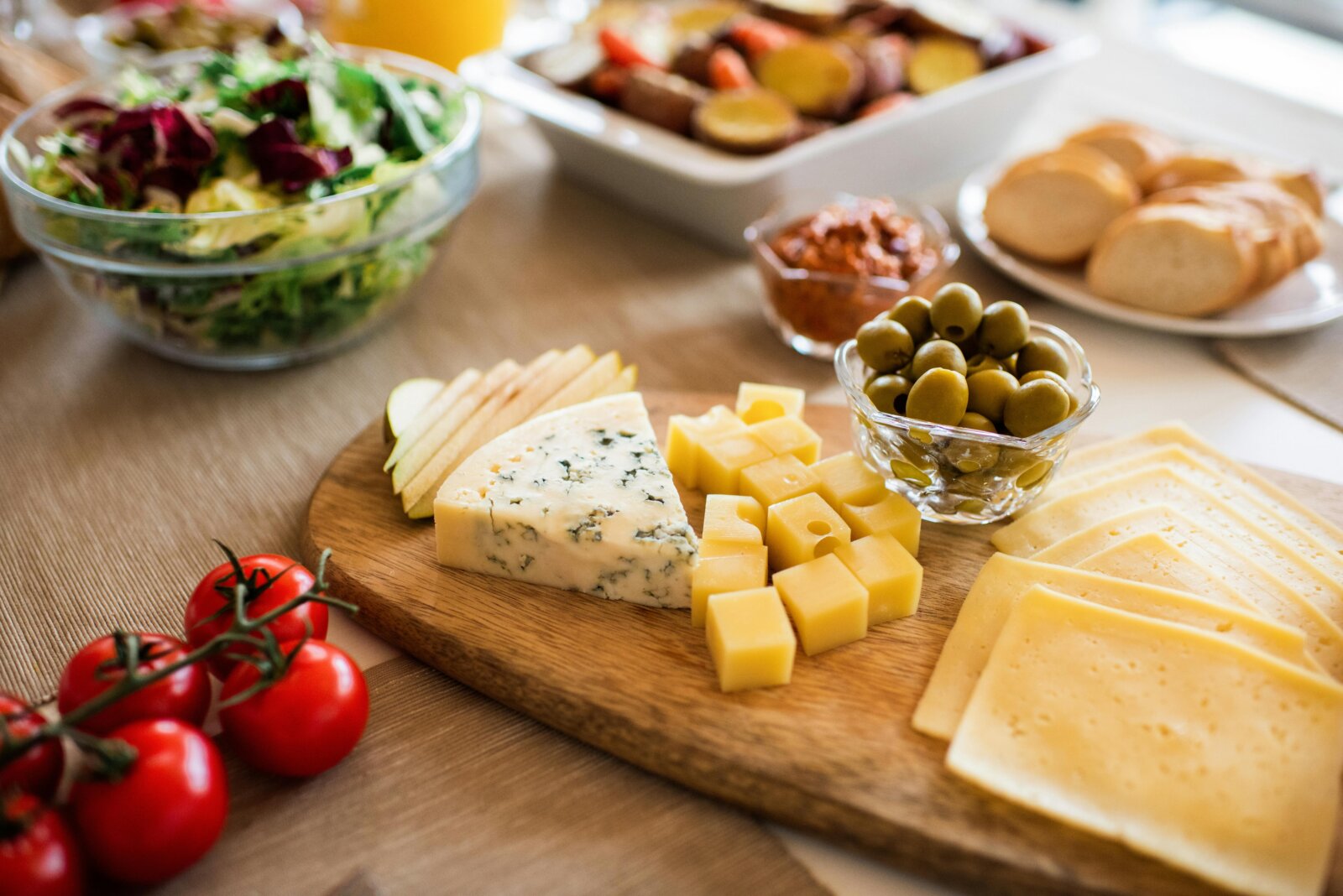 A Portuguese cheese platter with olives, cherry tomatoes, and bread, a traditional selection included in Premium Tours’ gastronomic experiences in Portugal.