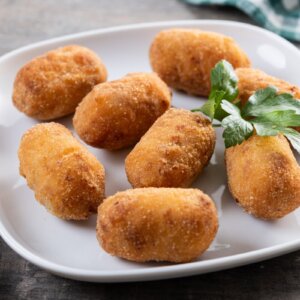 Traditional Portuguese codfish croquettes served on a white plate.