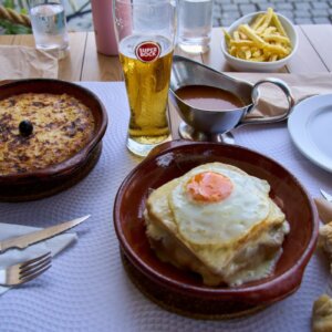 Traditional Francesinha served with fries, beer and Portuguese comfort food dishes at a local restaurant in Porto.
