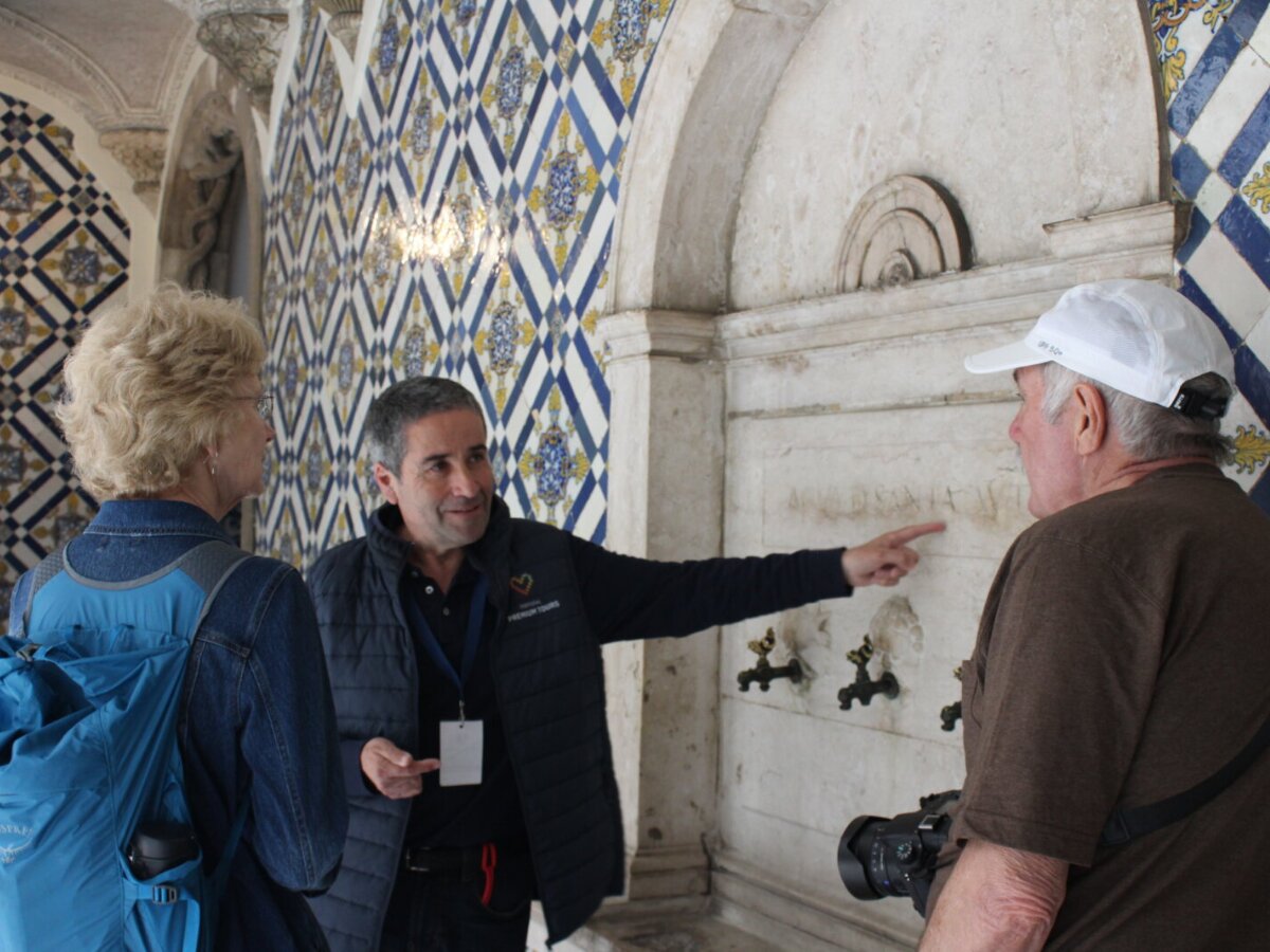 Cultural Tour with Guide Carlos Godinho Guide Carlos Godinho explaining historical details beside traditional Portuguese tiles.