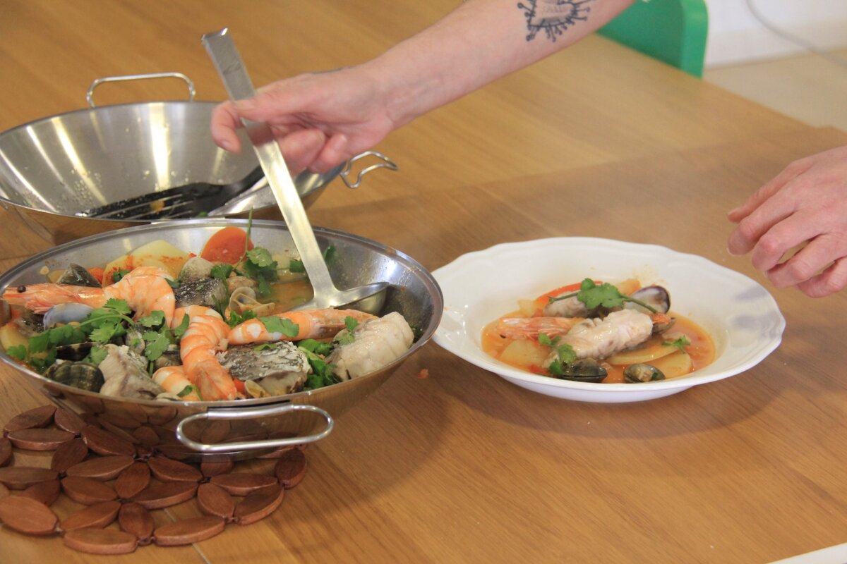 Cataplana Culinary Experience in Portugal Person serving a traditional Portuguese cataplana, freshly prepared