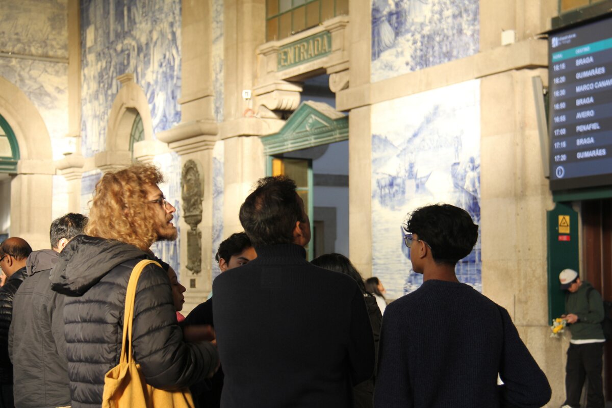 Clients exploring São Bento Train Station in Porto with guide José, surrounded by traditional Portuguese azulejos.