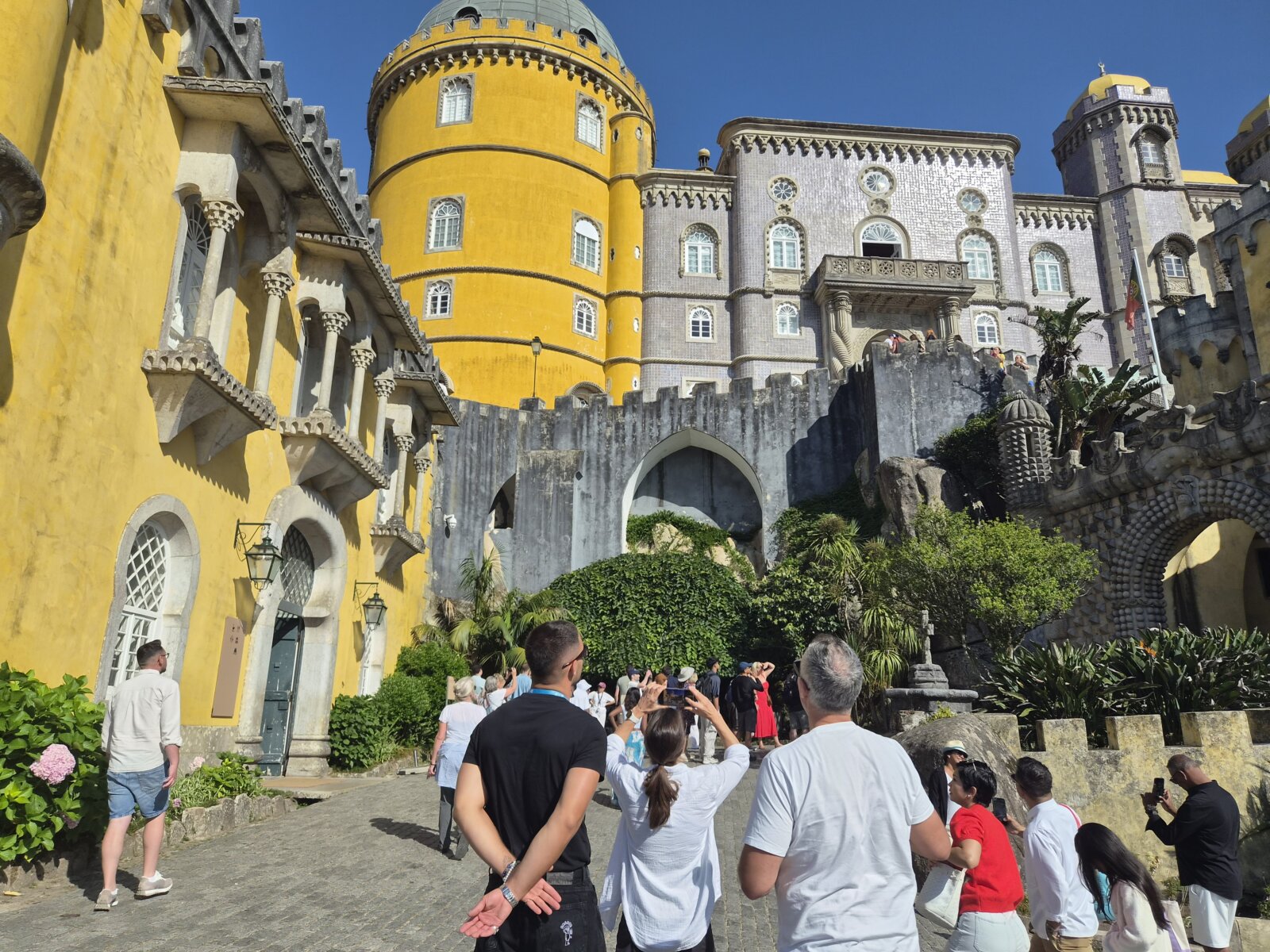 Private guide leading clients through the courtyard of Pena Palace in Sintra, Portugal.