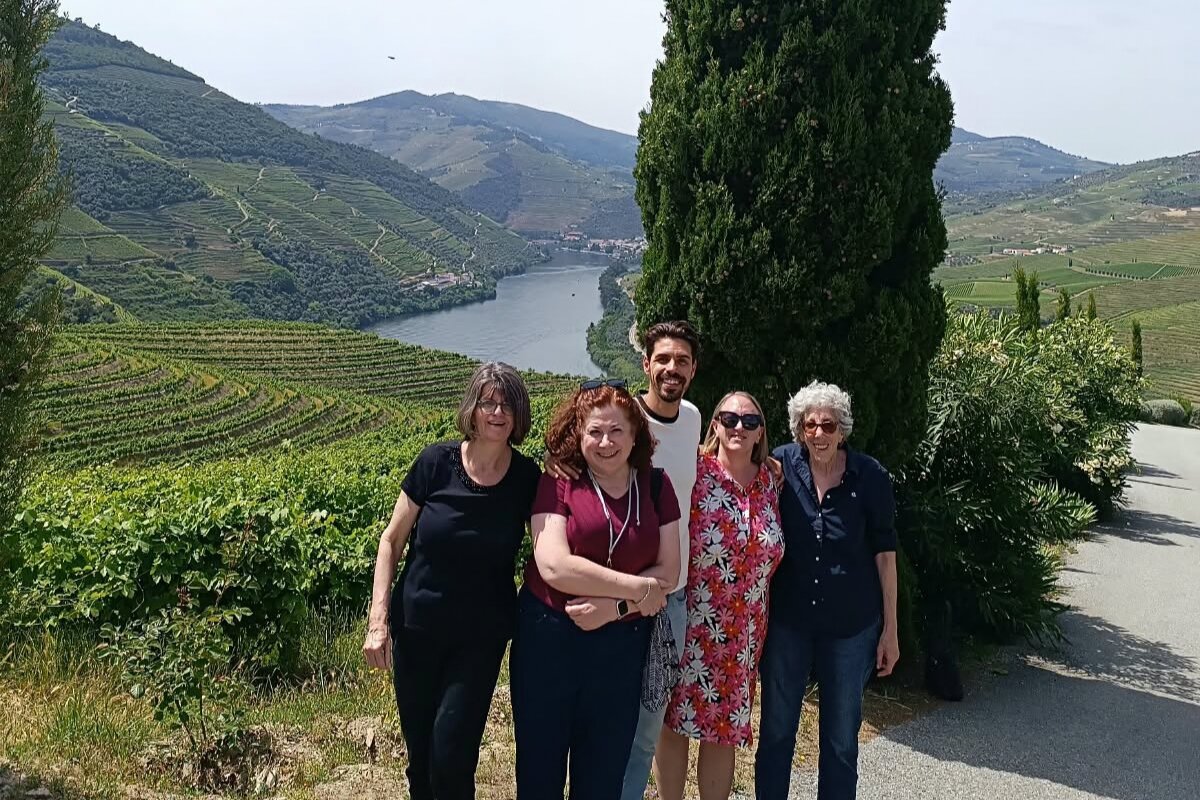 Portugal Premium Tours guide Daniel with clients overlooking the Douro River, terraced vineyards and beautiful green hills in Portugal's Douro Valley.